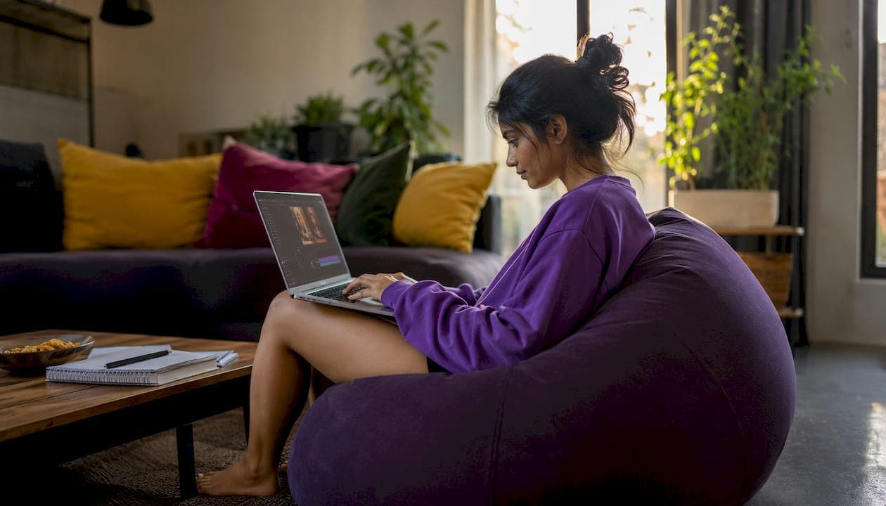 Woman editing skit video on laptop in home studio